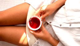 デトックスティーをお腹に当てて飲む女性