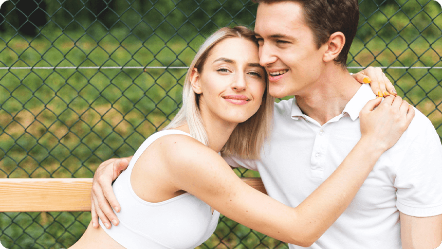 スポーツ後のカップルが顔を近づけて抱き合う姿