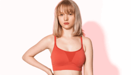 赤いブラトップを着た女性が無表情でこちらを見る様子。体型や下着に関する悩みを連想させるシーン