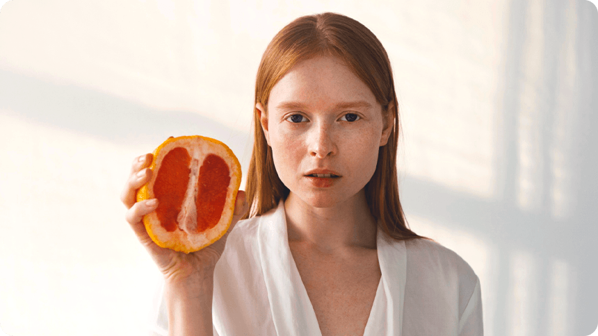どこか不安そうな女性がグレープフルーツを握りしめる様子