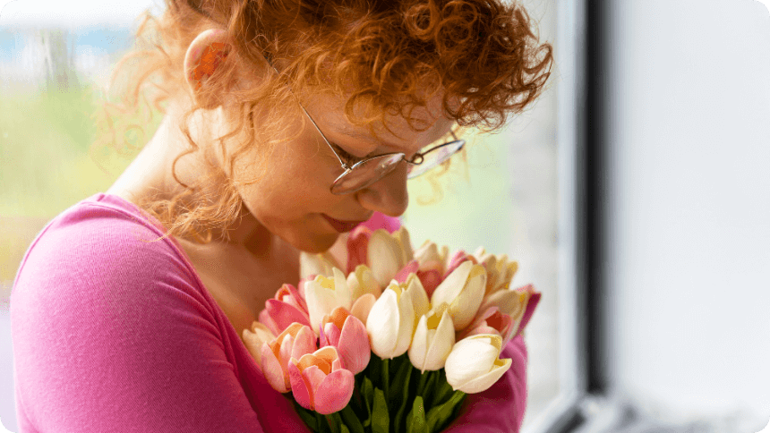 チューリップの花束を抱えて何かを考えている女性