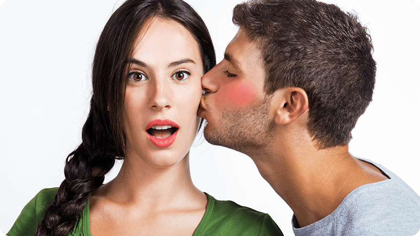 顔を赤らめた男性に頬にキスをされ驚く女性