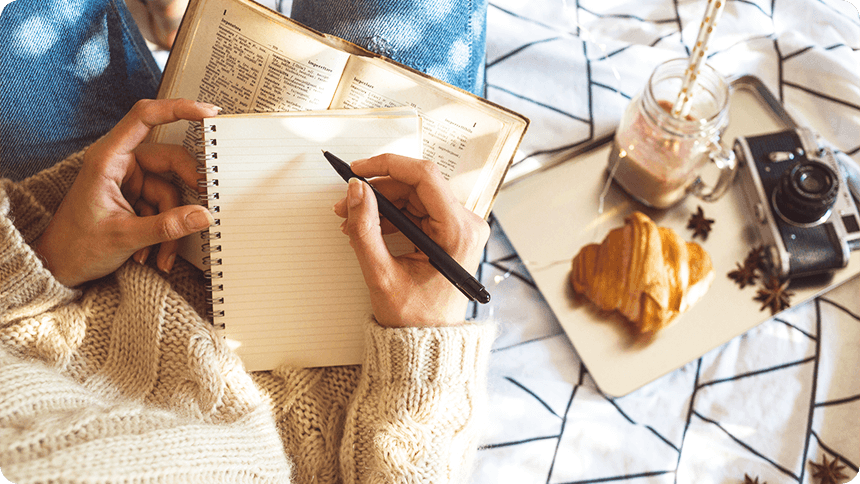 ペンと持ってノートに書き込もうとする女性の手