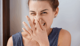 若い女性が強い匂いを避けるように鼻をつまんでいる。ニオイに嫌悪感を示す表情