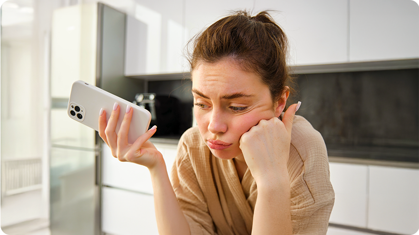 不機嫌そうにスマホを持ち頬杖をつく女性