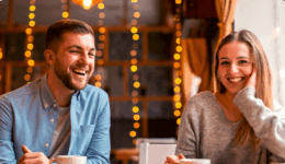 カフェで向かい合い、笑顔で会話を楽しむ男女のカップル