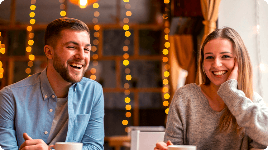 カフェで向かい合い、笑顔で会話を楽しむ男女のカップル