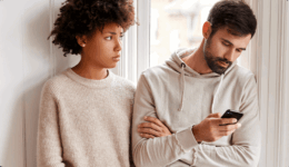 窓辺で、スマホを見続ける男性と困った表情で見つめる女性