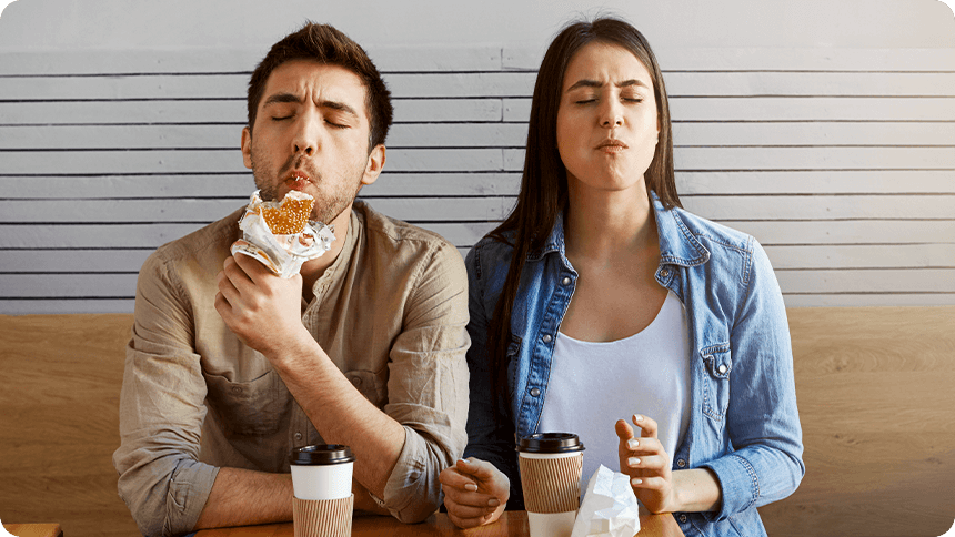 テーブルに飲み物を置き、並んで座る男女