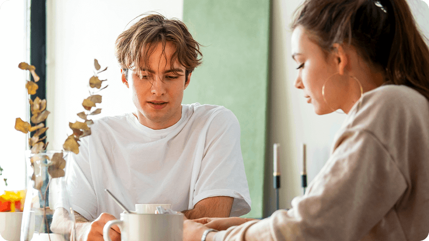 テーブルを挟んで向かい合い、話をしている男女