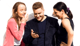 女友達に囲まれてスマホを見ながら楽しそうに笑う男性