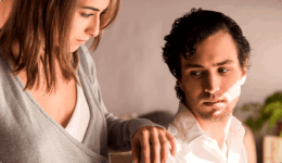 男性の肩に手を置きながら不安そうな表情をする女性