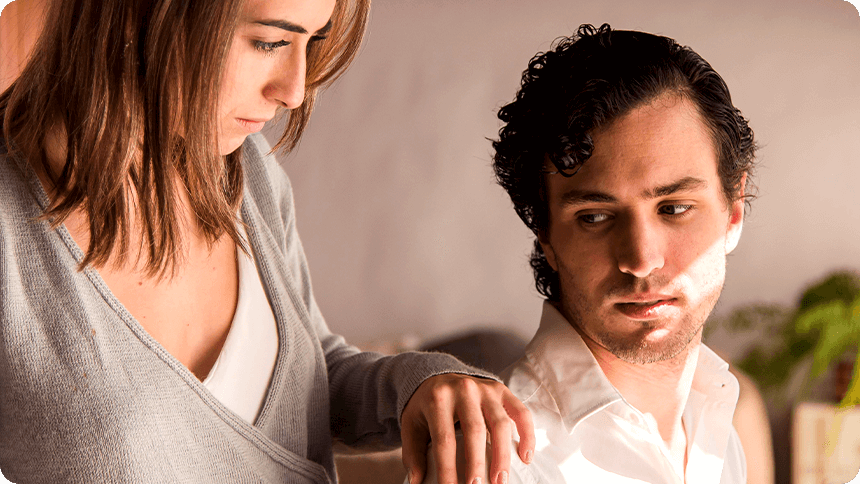 男性の肩に手を置きながら不安そうな表情をする女性