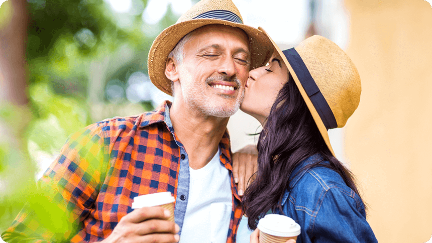 男性の頬にキスをする若い女性カップル