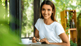 他人との比較を卒業し、穏やかな表情で『恋愛予祝ノート』を書き始める女性。自分自身と向き合い、未来の幸せなイメージを今先取りして楽しむ、クリエイティブで前向きなひととき。