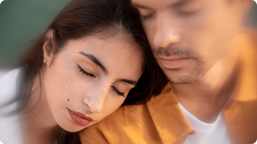 ぼやけた男性の肩にもたれて眠る女性