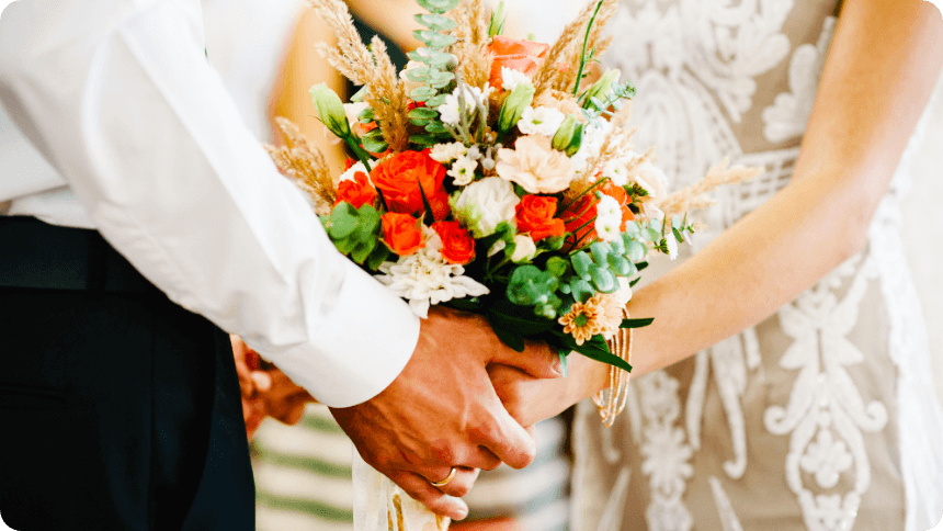 華やかな花束を二人で持つ結婚式のカップル