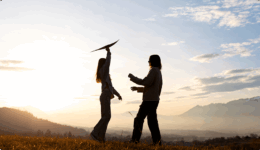 芝生の上でリラックスして横たわり、穏やかな笑顔で彼と見つめ合う女性。心の澱（おり）が取れて、素直な気持ちを伝えている幸せな対話のシーン