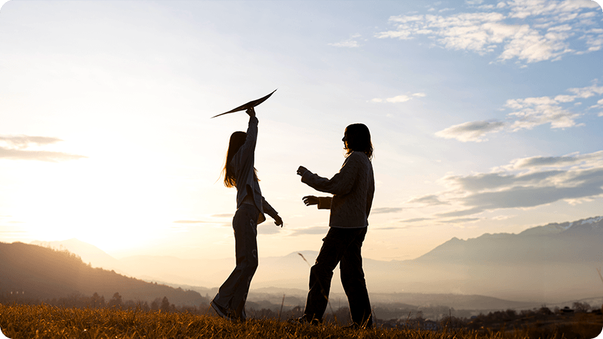 芝生の上でリラックスして横たわり、穏やかな笑顔で彼と見つめ合う女性。心の澱（おり）が取れて、素直な気持ちを伝えている幸せな対話のシーン