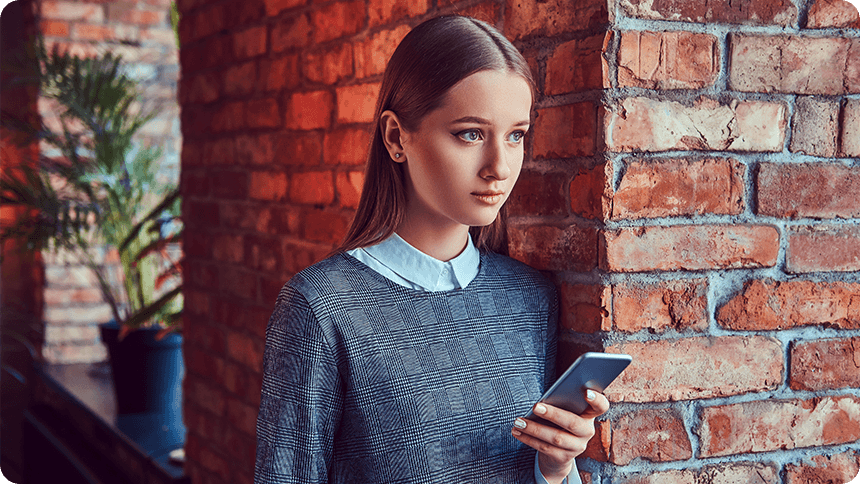 携帯を見てシリアスな表情を浮かべる女性
