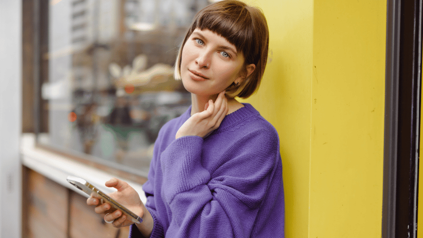 スマートフォンを手に持ち、LINEのやり取りについて考えているような知的な女性のイメージ
