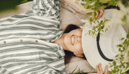 帽子を目元に置き、穏やかな表情で自分の気持ちと向き合う女性
