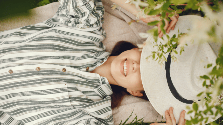 帽子を目元に置き、穏やかな表情で自分の気持ちと向き合う女性