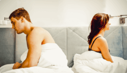 ベッドで背中を向き不機嫌そうな男女