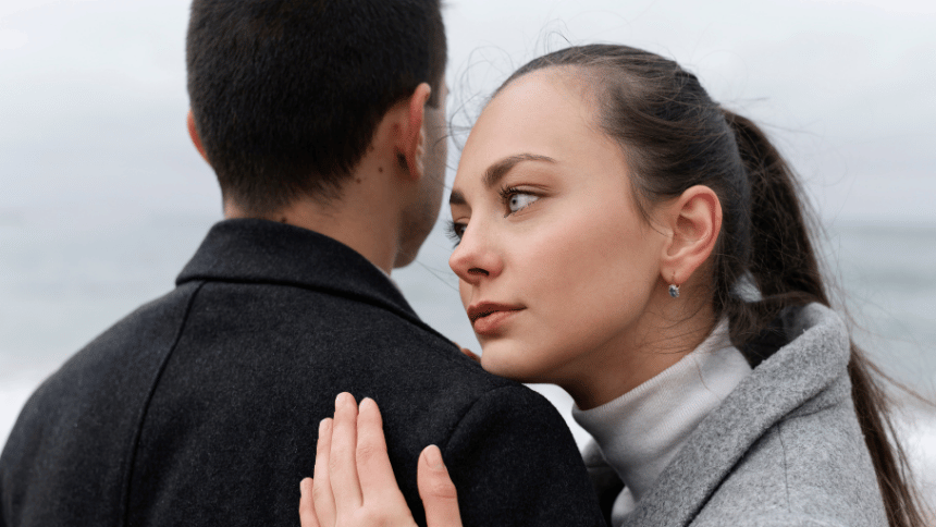 彼に寄り添いながら、本当の自分を隠しているような表情を見せる女性