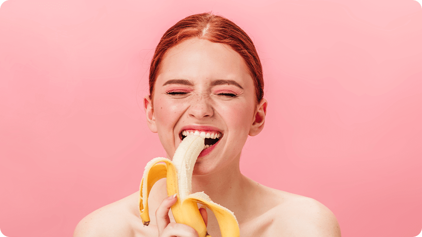 笑顔でバナナを加える女性