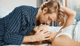 ベッドに横になる女性にキスをしようとする男性