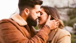 男性が女性の顔に手をやさしく添えながら、キスをしようとしているカップル